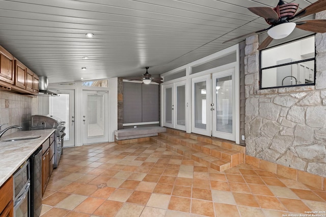 kitchen with french doors, brown cabinets, stainless steel range oven, a sink, and ceiling fan