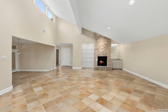 unfurnished living room with high vaulted ceiling, a fireplace, visible vents, and baseboards