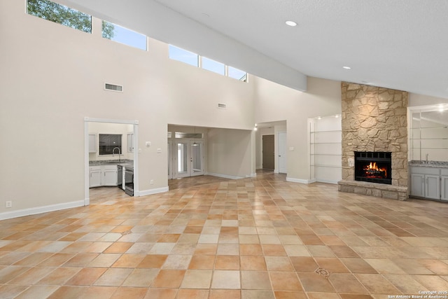 unfurnished living room with light tile patterned floors, visible vents, a fireplace, and baseboards