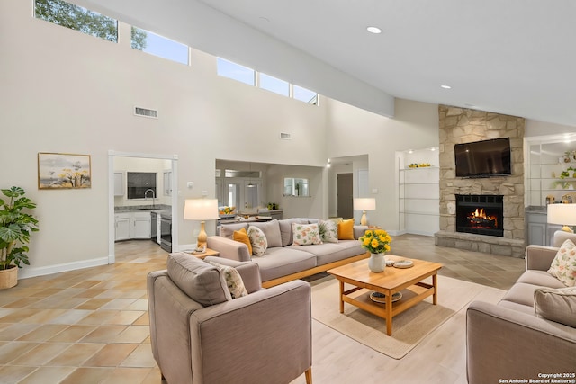 living room featuring visible vents, a fireplace, baseboards, and light tile patterned floors