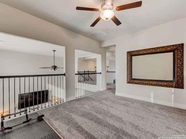 unfurnished room with carpet floors, visible vents, and baseboards