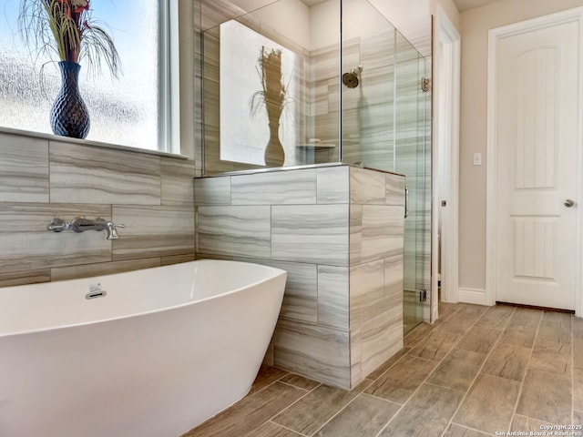 bathroom featuring a freestanding bath, a shower stall, tile walls, and wood tiled floor