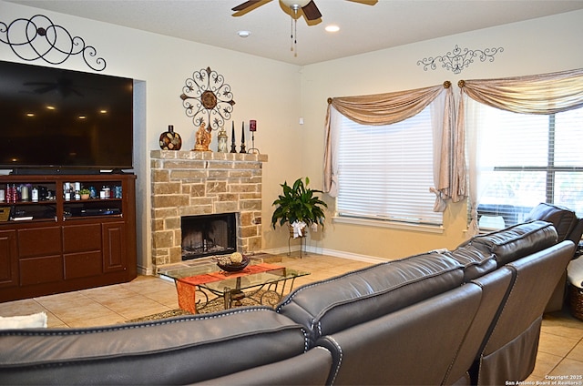 living room with light tile patterned floors, baseboards, ceiling fan, a stone fireplace, and recessed lighting