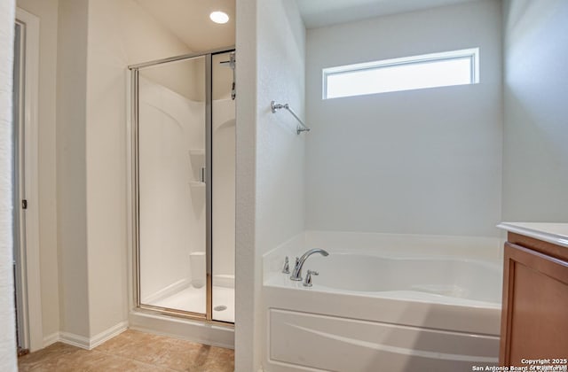 bathroom featuring a bath, a stall shower, tile patterned flooring, and vanity