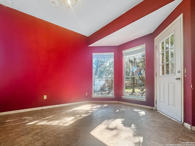 empty room with baseboards and a textured ceiling