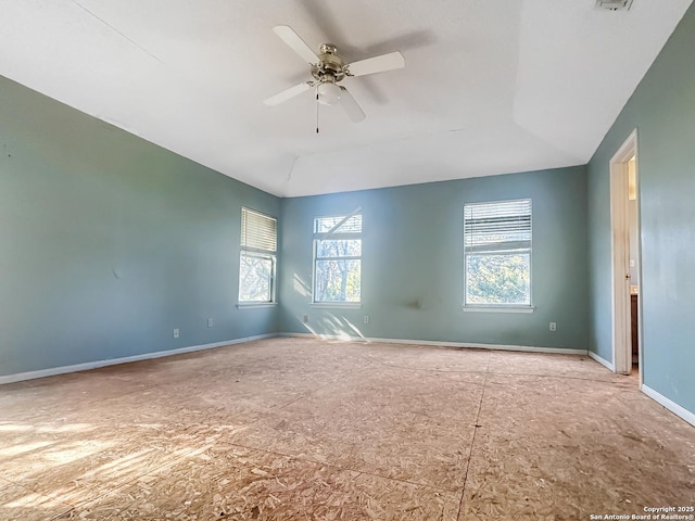 spare room with a ceiling fan, lofted ceiling, and baseboards