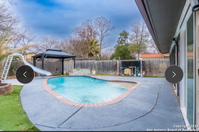 view of pool with a water slide, a fenced backyard, a gazebo, a fenced in pool, and a patio area