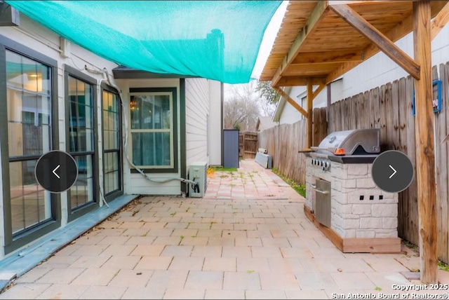 view of patio with area for grilling and a fenced backyard