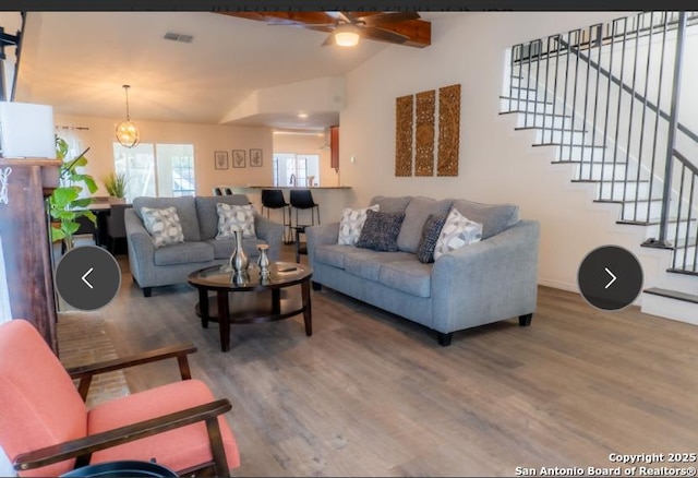 living room with visible vents, lofted ceiling with beams, a ceiling fan, wood finished floors, and stairs