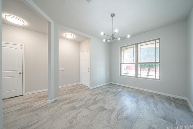 interior space featuring a chandelier and baseboards