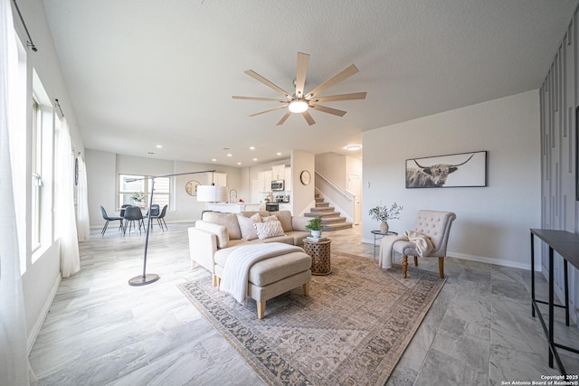 living room with stairs, baseboards, a textured ceiling, and recessed lighting