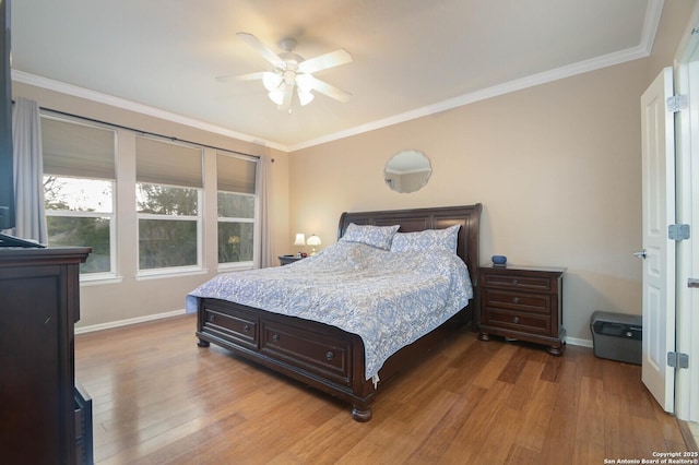 bedroom featuring ornamental molding, light wood-type flooring, and baseboards