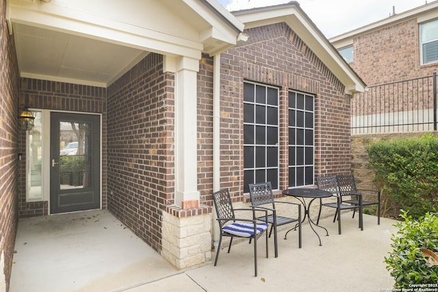 doorway to property featuring a patio area and brick siding