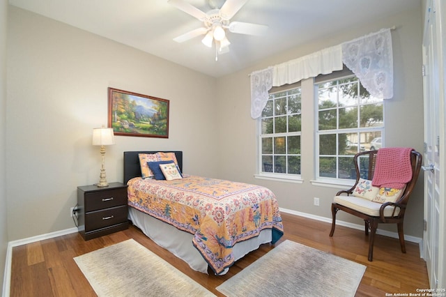 bedroom featuring ceiling fan, baseboards, and wood finished floors