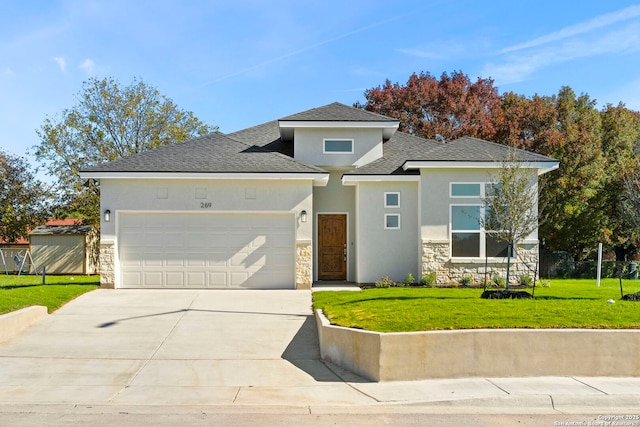 prairie-style house with a front yard, stone siding, driveway, and stucco siding