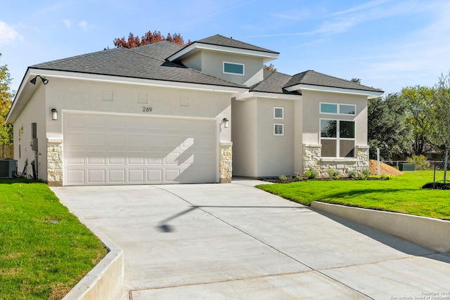 prairie-style house with stone siding, a front lawn, driveway, and stucco siding