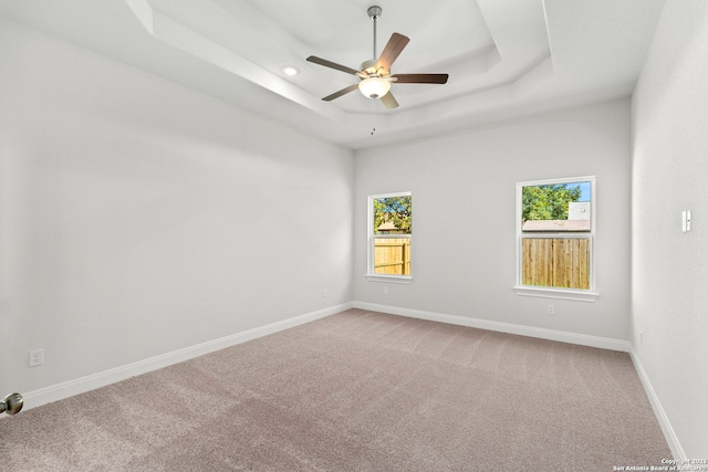 carpeted spare room with ceiling fan, recessed lighting, a raised ceiling, and baseboards