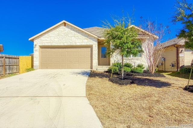 ranch-style house featuring concrete driveway, stone siding, an attached garage, and fence