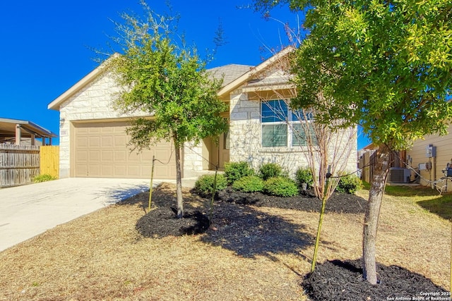 view of front of property featuring concrete driveway, an attached garage, fence, cooling unit, and stone siding