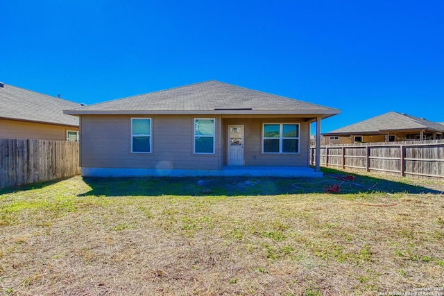 rear view of house with a patio area, a fenced backyard, and a yard