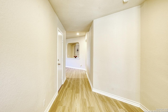 hallway featuring light wood-style floors and baseboards