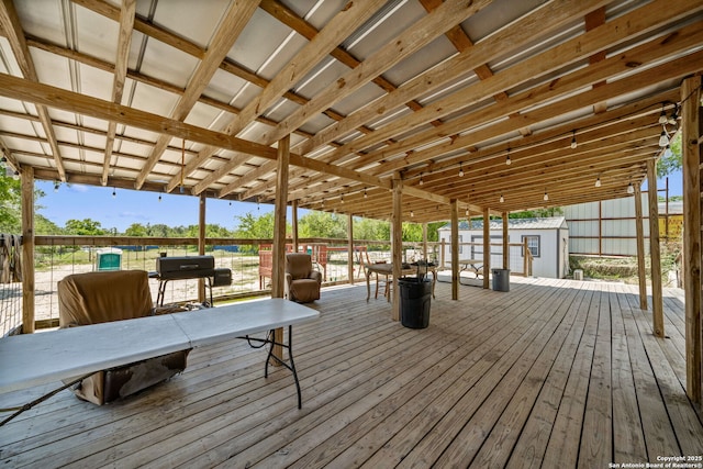 wooden deck featuring a storage shed and an outdoor structure