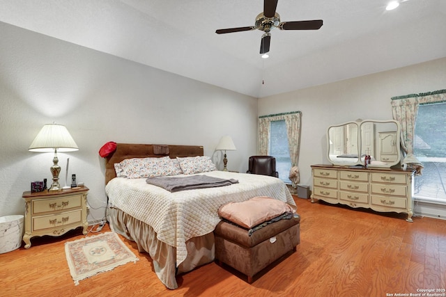 bedroom featuring lofted ceiling, light wood-style flooring, and ceiling fan