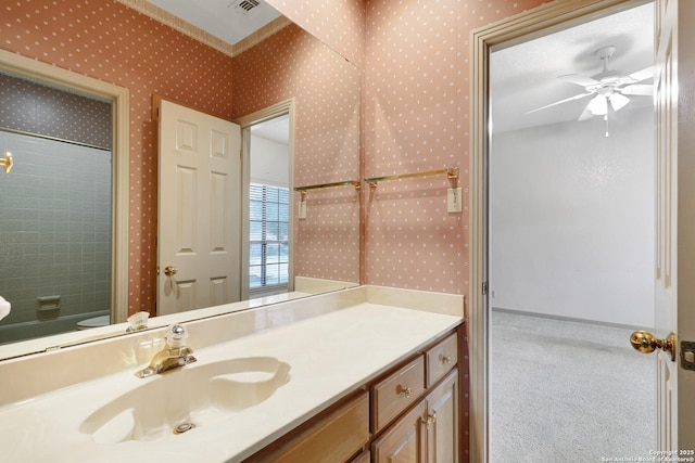 bathroom with visible vents, vanity, baseboards, and wallpapered walls