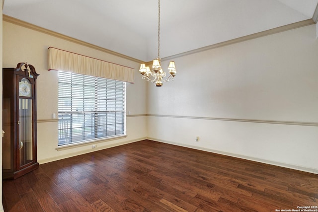 empty room with baseboards, lofted ceiling, dark wood-style floors, ornamental molding, and a chandelier