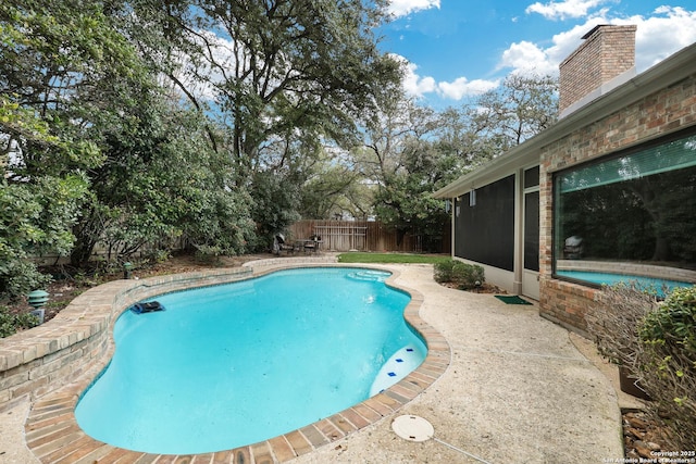 view of swimming pool featuring a sunroom, a patio, a fenced backyard, and a fenced in pool