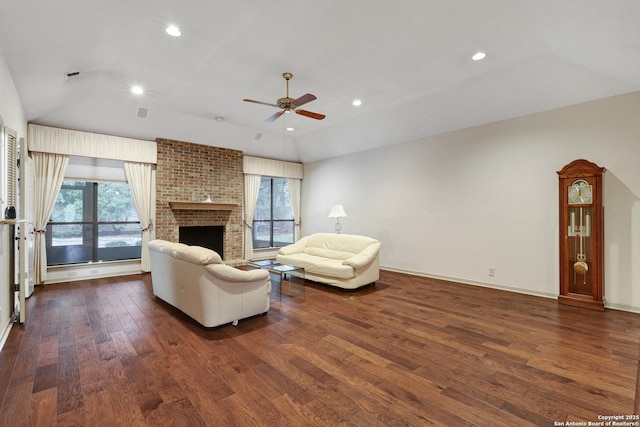 living area featuring dark wood-style floors, lofted ceiling, a fireplace, and plenty of natural light