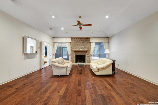 living area with vaulted ceiling, dark wood-style floors, and a healthy amount of sunlight