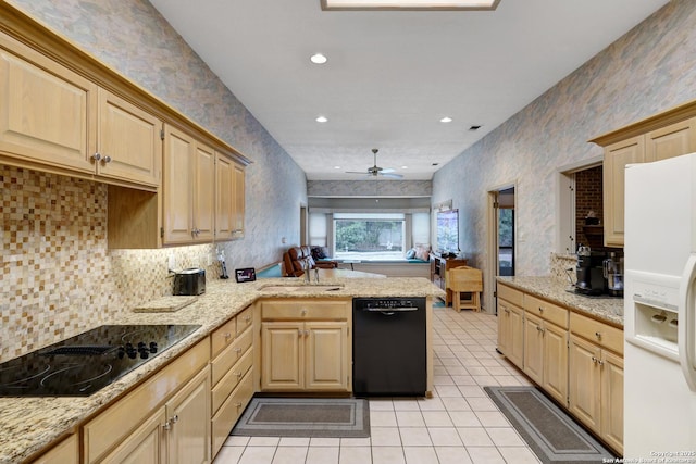 kitchen with a peninsula, black appliances, light brown cabinets, and open floor plan