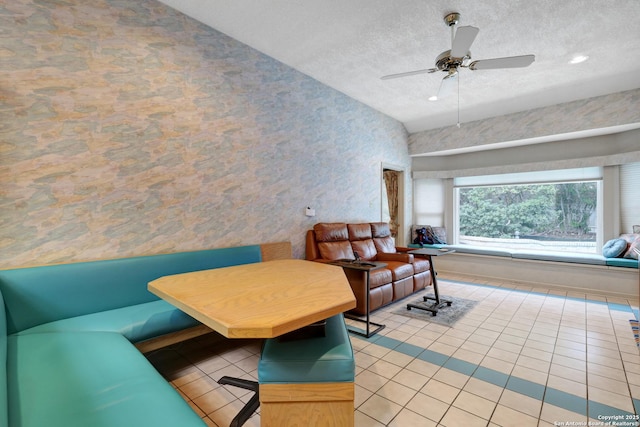 living room with a textured ceiling, light tile patterned flooring, and a ceiling fan