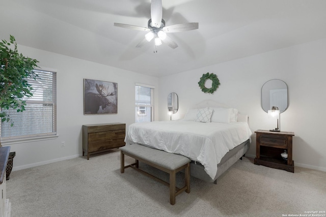 bedroom with a ceiling fan, light colored carpet, and baseboards