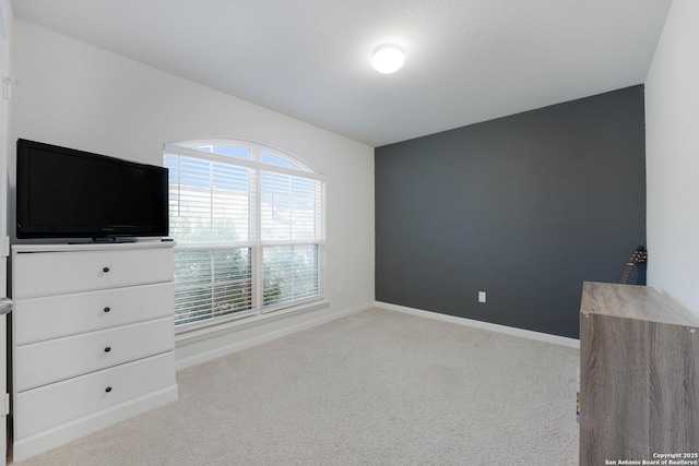 unfurnished bedroom with baseboards and light colored carpet