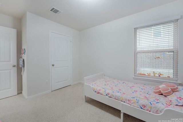 bedroom featuring baseboards, visible vents, and light colored carpet