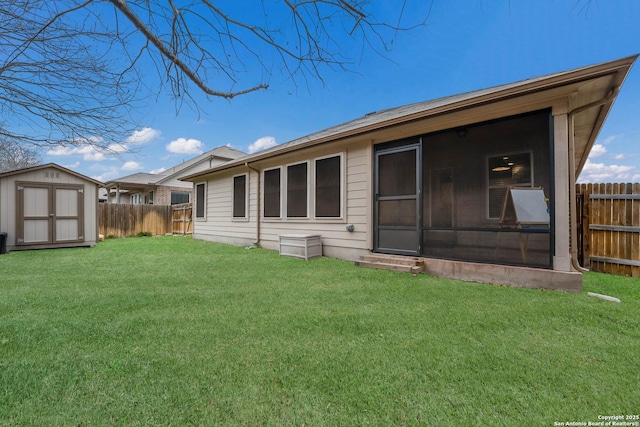 back of house with an outbuilding, a yard, a shed, and fence