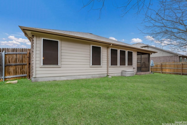 back of property featuring fence and a yard