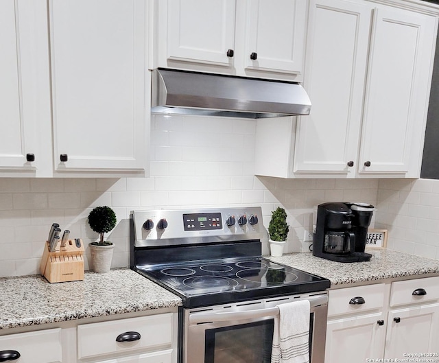 kitchen featuring under cabinet range hood, stainless steel range with electric stovetop, and white cabinets