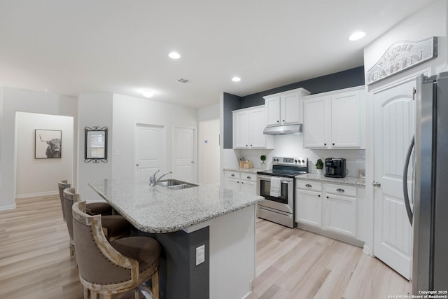 kitchen featuring stainless steel appliances, a kitchen island with sink, white cabinetry, and a sink