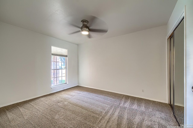 unfurnished bedroom with ceiling fan, a closet, carpet, and baseboards