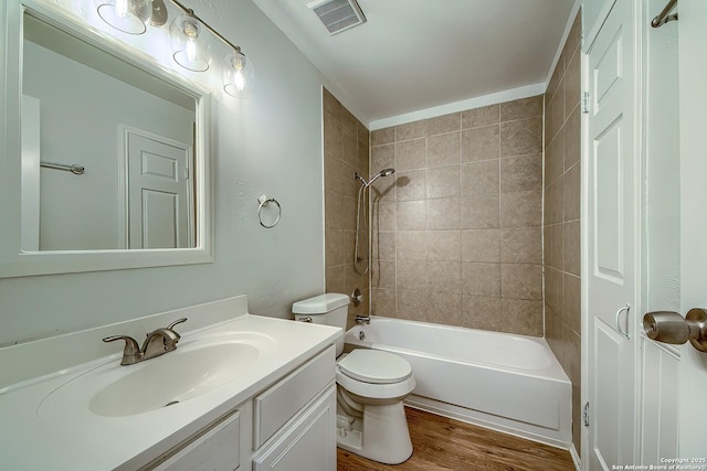 full bath featuring toilet, wood finished floors, vanity, visible vents, and washtub / shower combination