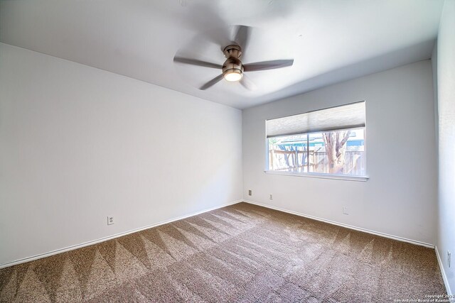 spare room with ceiling fan, carpet floors, and baseboards