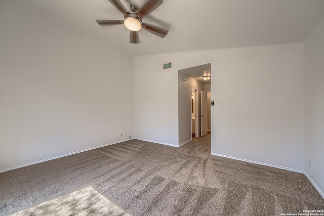 spare room with lofted ceiling, baseboards, visible vents, and carpet flooring