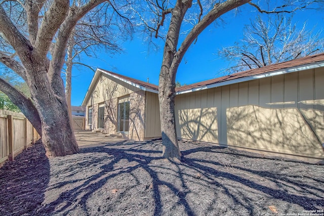 view of home's exterior featuring board and batten siding and fence