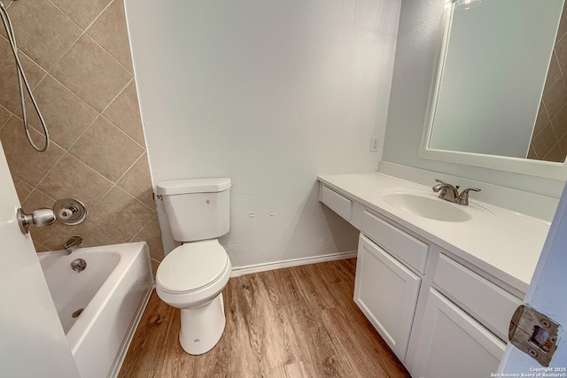 full bath featuring toilet, wood finished floors, vanity, baseboards, and tub / shower combination