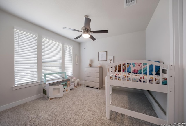 bedroom featuring light colored carpet, visible vents, ceiling fan, a crib, and baseboards