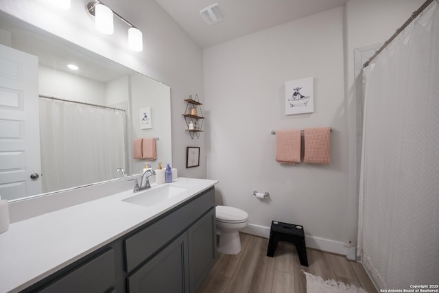 full bath with toilet, wood finished floors, vanity, visible vents, and baseboards