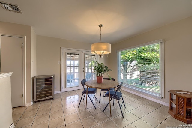 dining room featuring beverage cooler, visible vents, french doors, and a healthy amount of sunlight